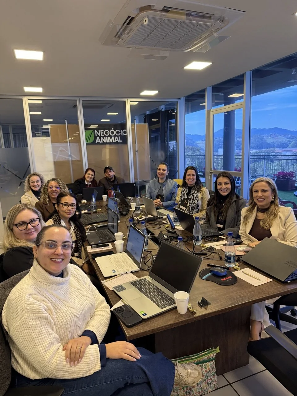 Grupo reunido em uma mesa com notebooks durante um workshop